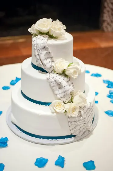 Tiered white wedding cake with roses